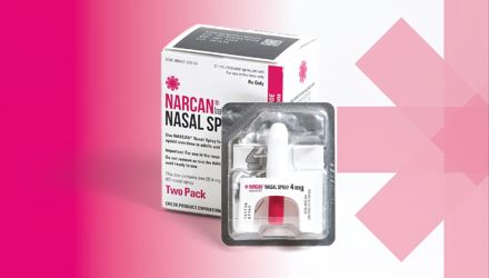 Box of NARCAN Nasal Spray with a sealed single dose in the foreground. Pink background gradating to white, from left to right. Brand logo on the far right background.