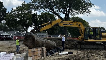 construction workers remove underground storage tank on construction site
